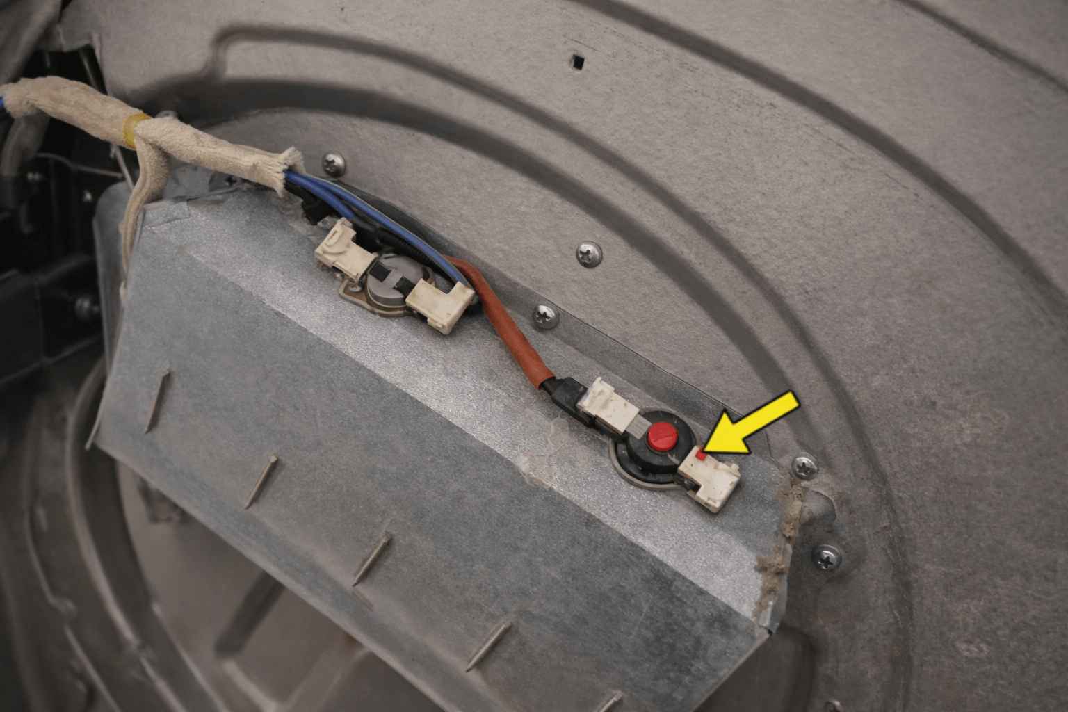 Voorbeeld van een clixon of temperatuurbegrenzer met resetknopje bij een wasdroger